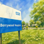 A large NHS Berrywood Hospital sign stands on grass, noting a Parish Council meeting change of venue.